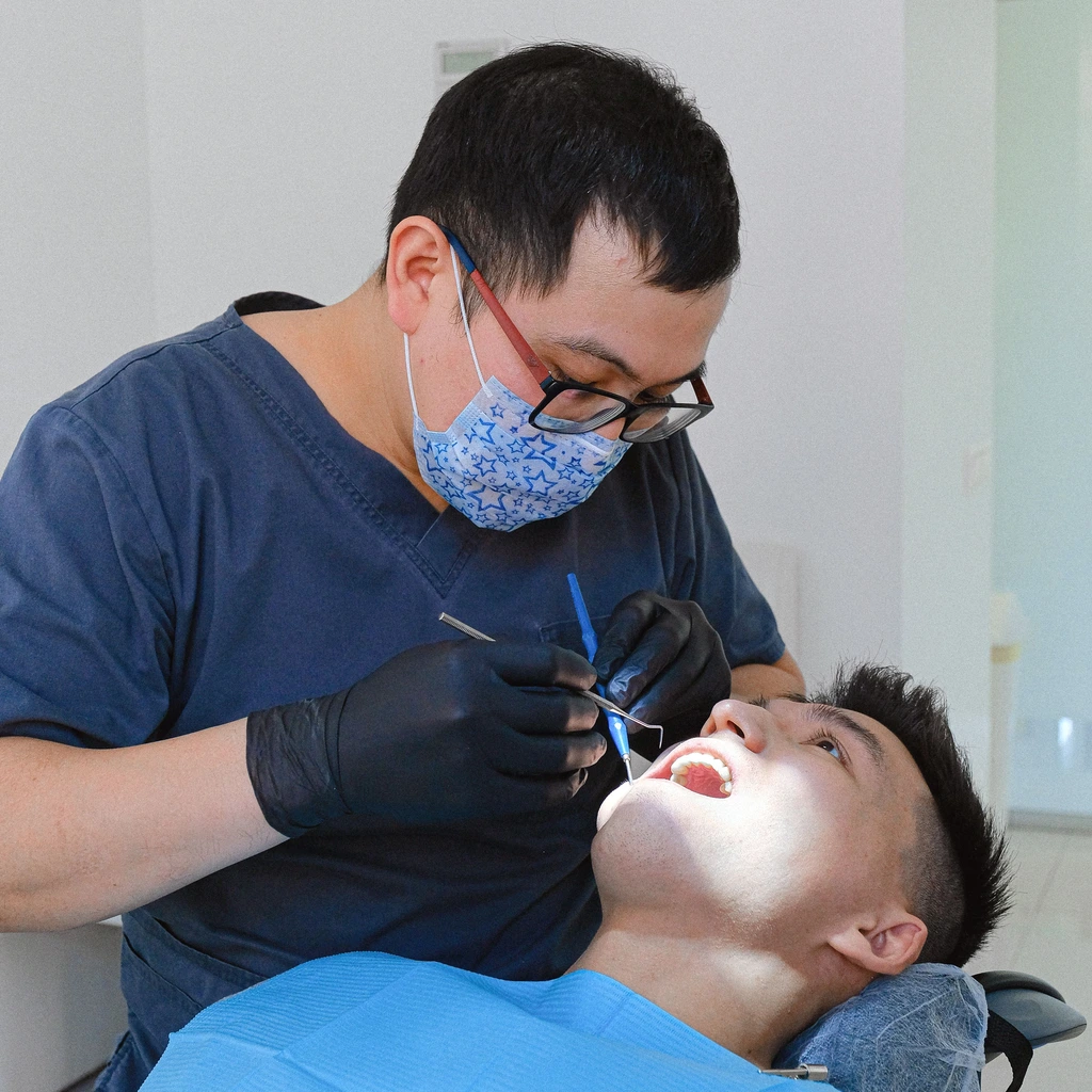Dentista realizando exame de escovacao para deteccao precoce do cancer de boca em consultorio odontologico moderno