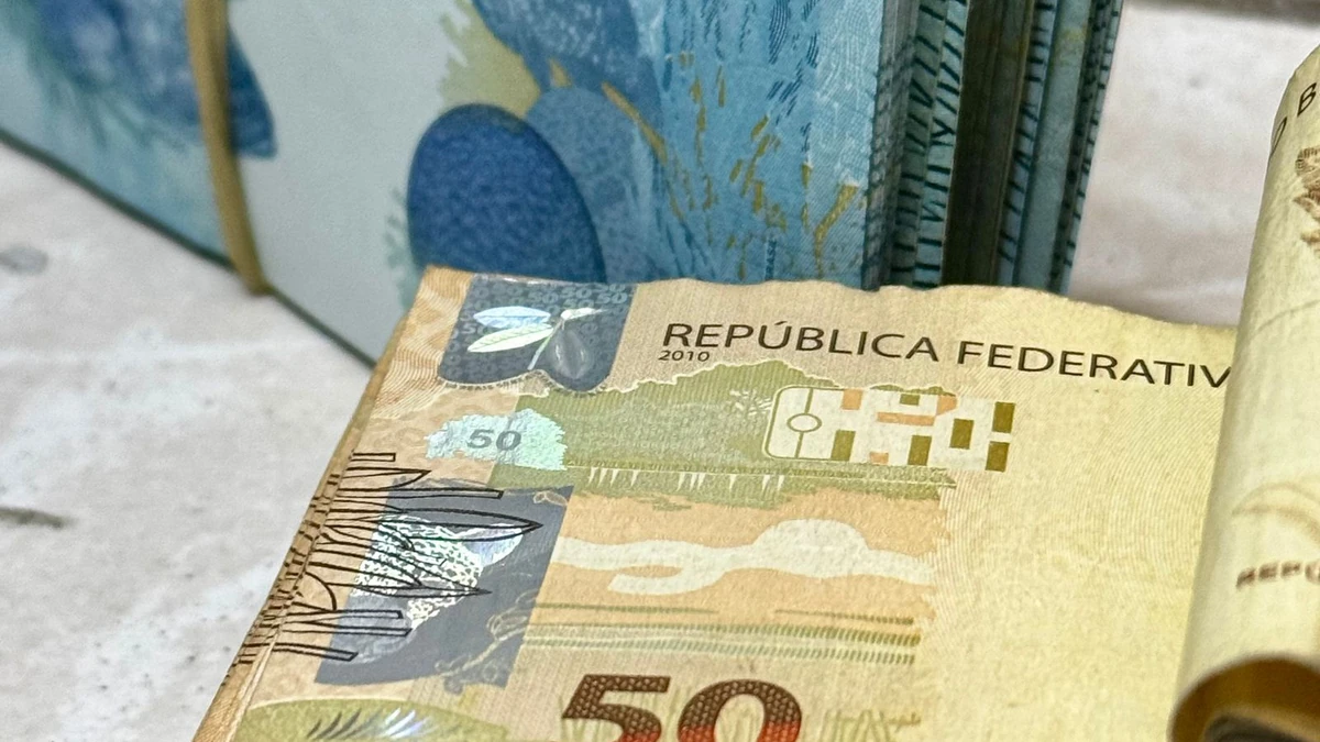 Pilhas de cédulas de 50 e 100 reais brasileiros empilhadas, tema da Operação Arena da Polícia Federal contra lavagem de dinheiro de apostas esportivas ilegais